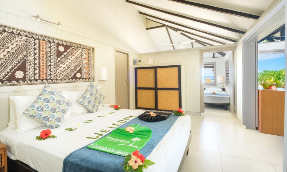 Interior view of the bedroom of a one bedroom beachfront bure at Plantation Island Resort Fiji