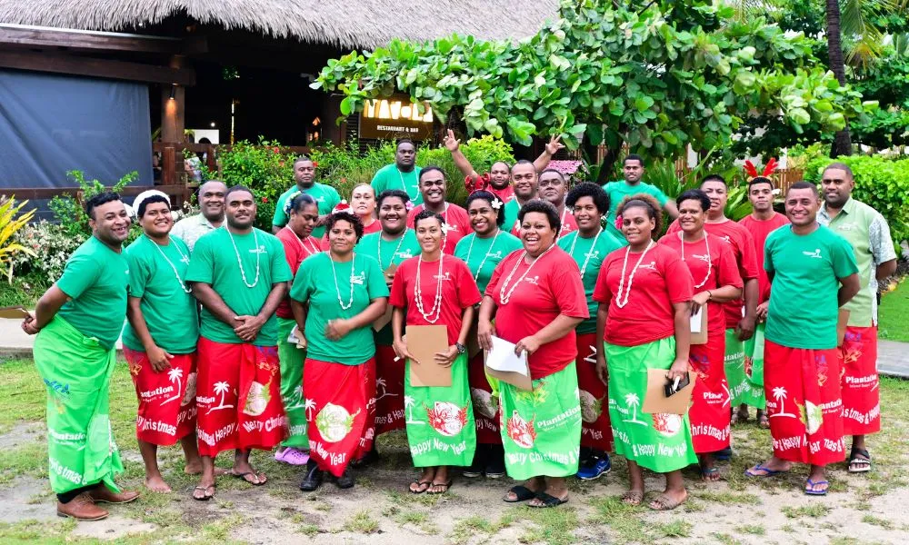 Plantation Island Resort staff in kalavata and matching shirts, holiday-themed.
