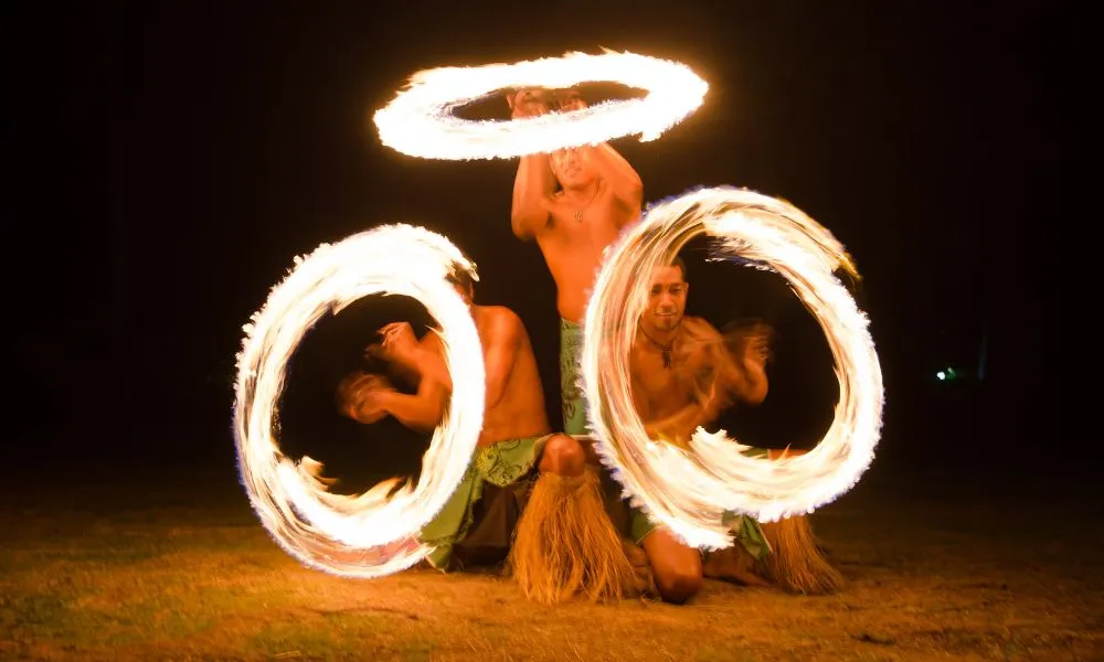 Three Fijian Warriors perform with fire at a culture performance on Plantation Island Resort