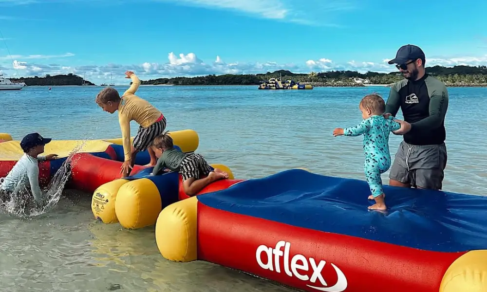 Children and adult playing on colourful inflatable float