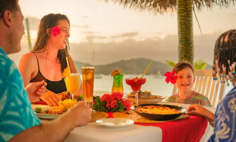 Mum, Dad, son and daughter happily sharing meal at Copra Restaurant table