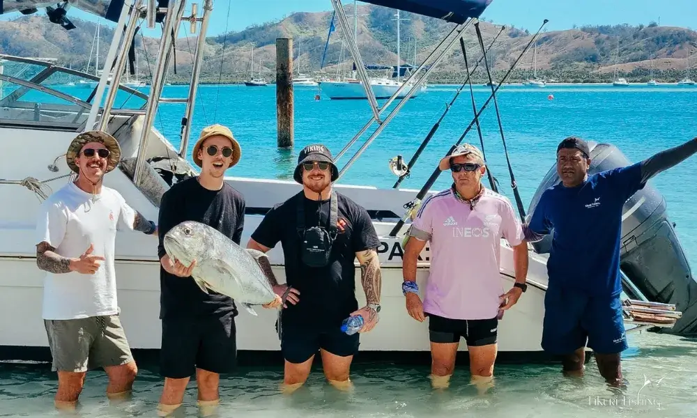 Happy group of anglers standing by their boat showing their catch of fish