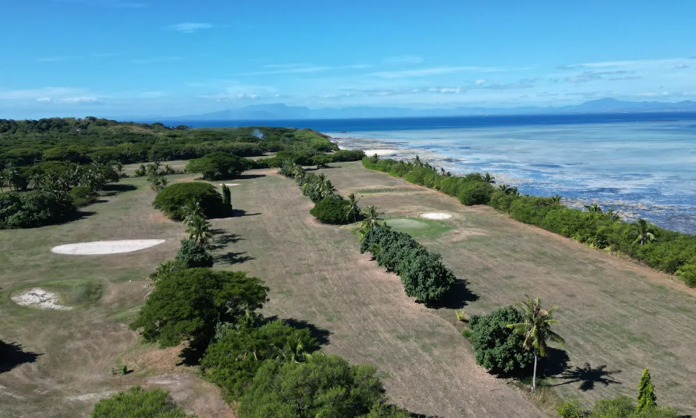 Aerial view of lush tropical golf course by the ocean