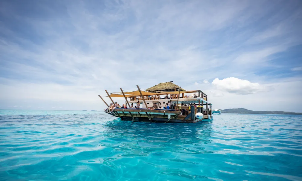 Floating bar boat on turquoise ocean under a blue sky