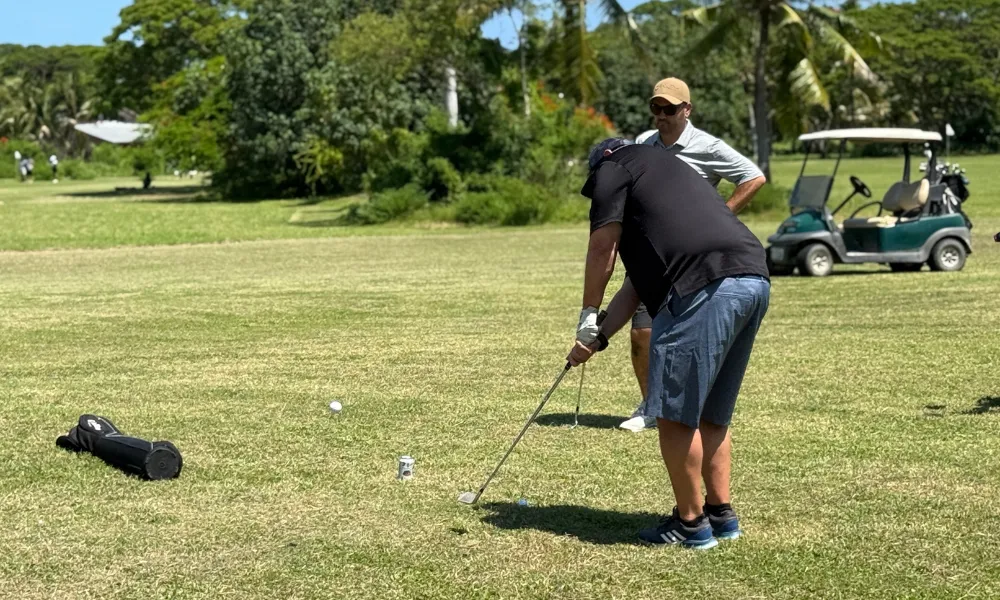 Golfer prepares to swing on a sunny green course