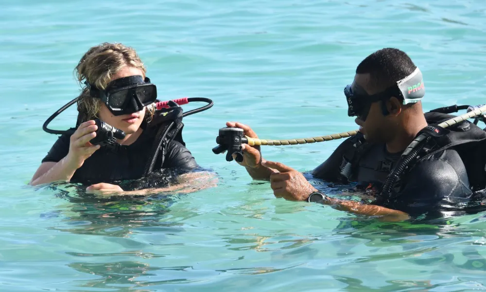 Instructor teaching a beginner how to scuba dive in Fiji