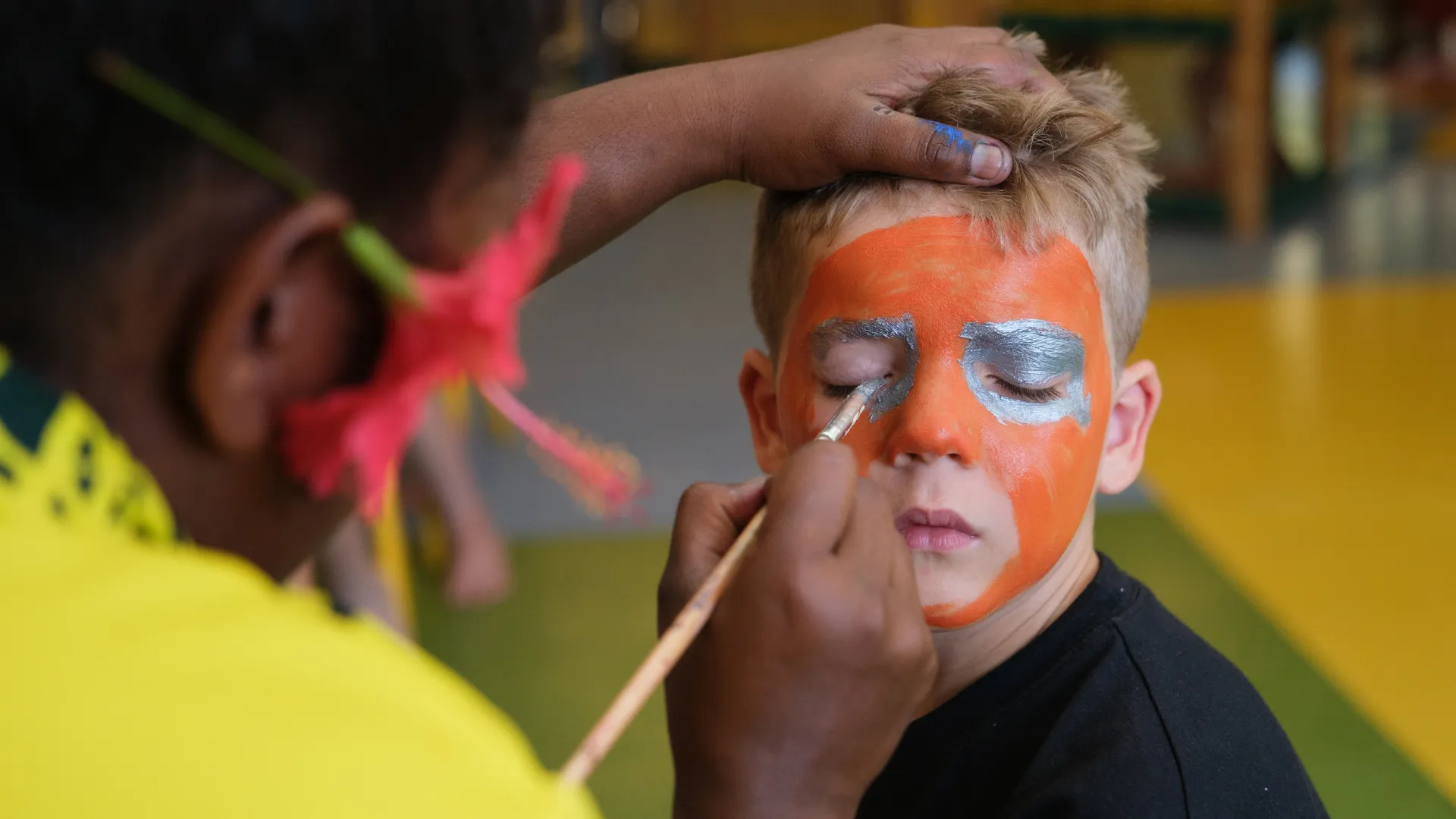 Young child having their face painted at the Coconut Kids Club