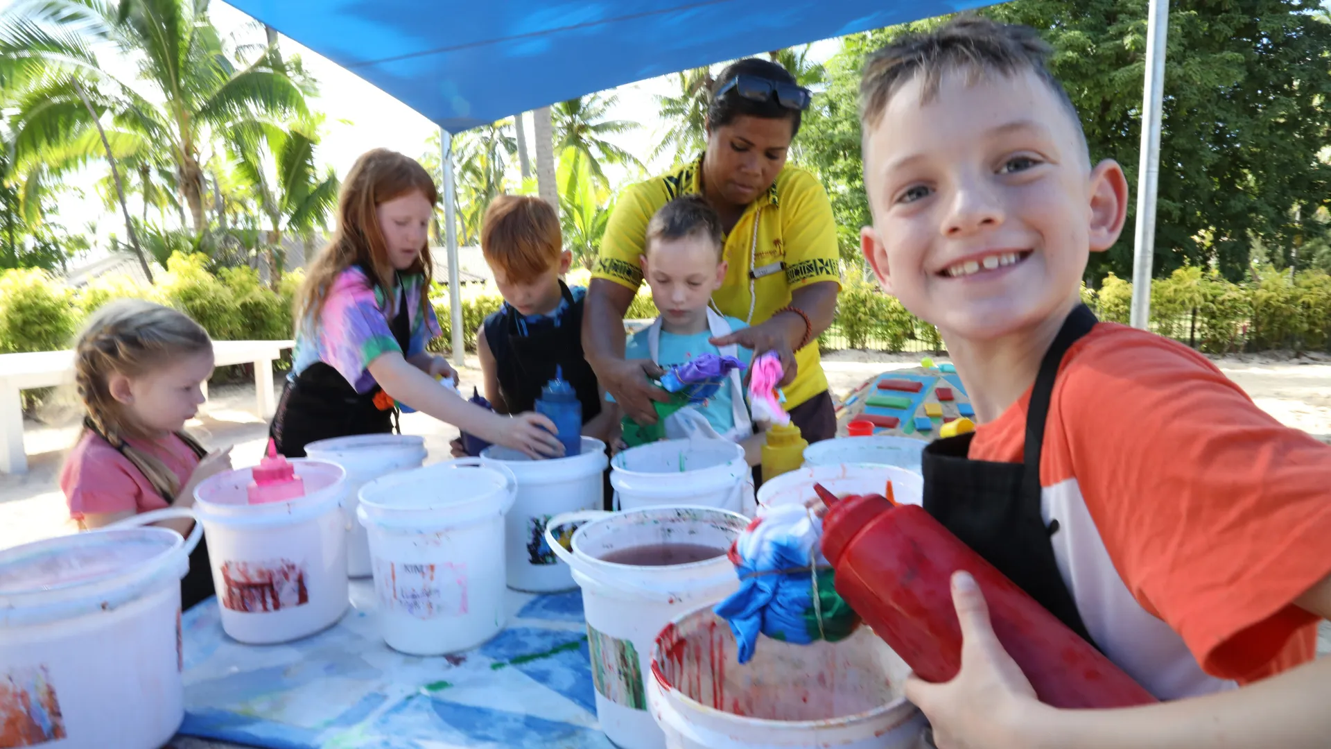 Kids tie-dyeing t-shirts at the Coconut Kids Club
