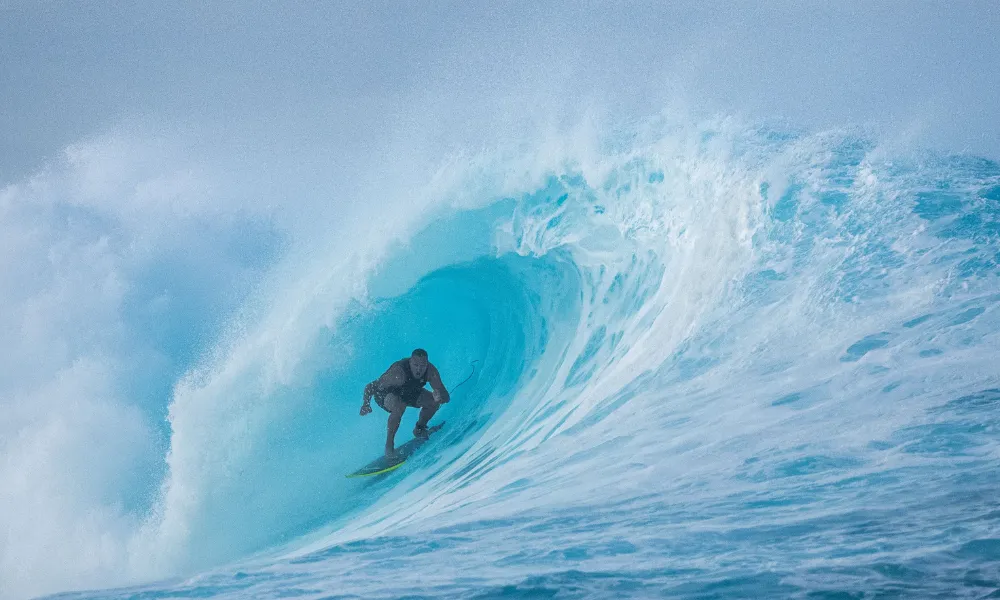 A male surfer carving a wave on a Fiji reef break