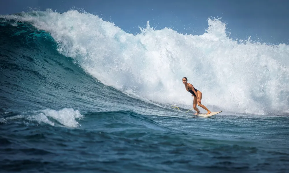 A surfer carving a wave on a Fiji reef break