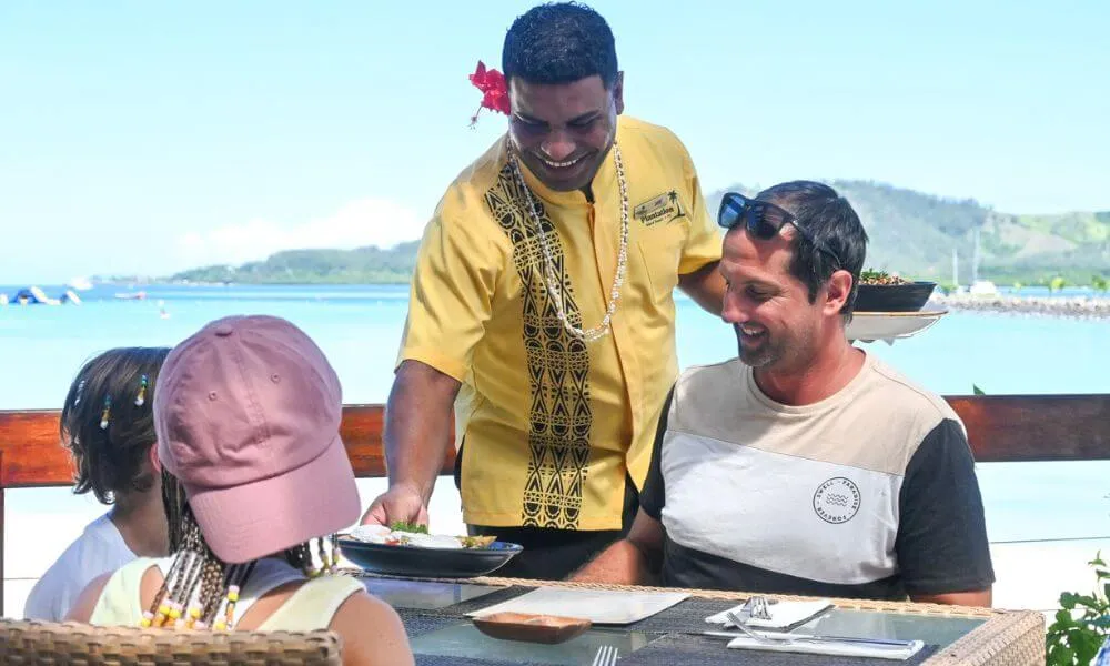 Family enjoying a meal together at Plantation Island Resort in Fiji
