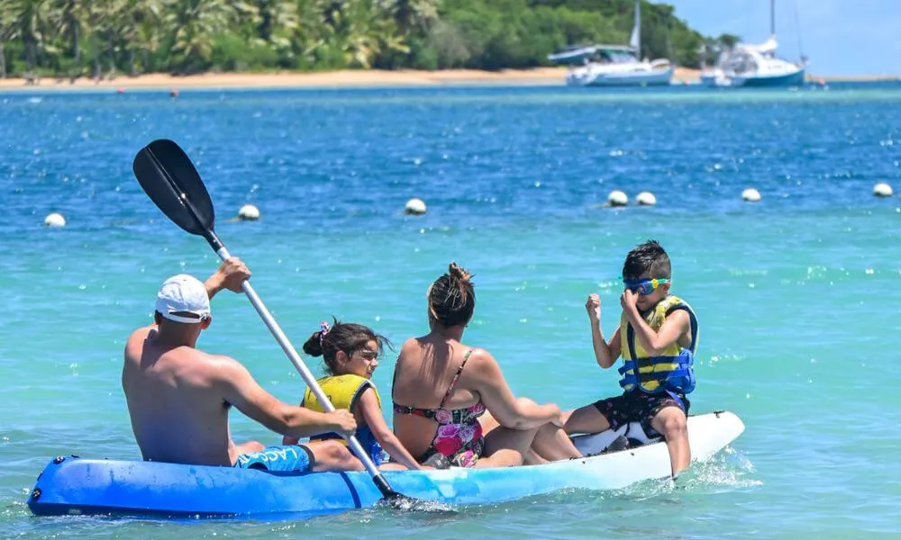 Family kayaking together on the turquoise waters at Plantation Island Resort