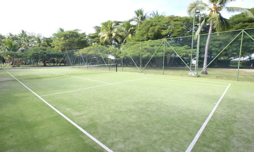 Outdoor tennis court surrounded by tropical gardens at Plantation Island Resort