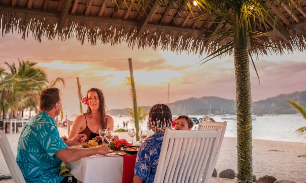 Family having dinner at sunset at Plantation Island Resort